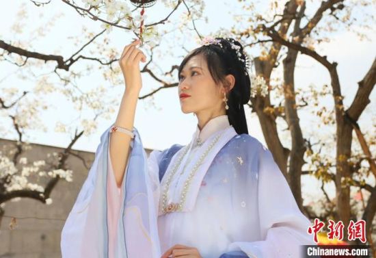 圖為蘭州青年身穿漢服在百年梨園賞景?！「哒?攝