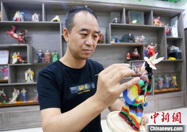 圖為安秋平正在創(chuàng)作代表隴南文縣民俗的《白馬人》作品?！「哒?攝