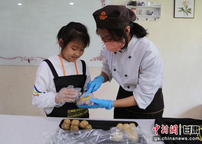 圖為在甘臺胞小朋友在工作人員指導(dǎo)下制作月餅。九美旦增 攝