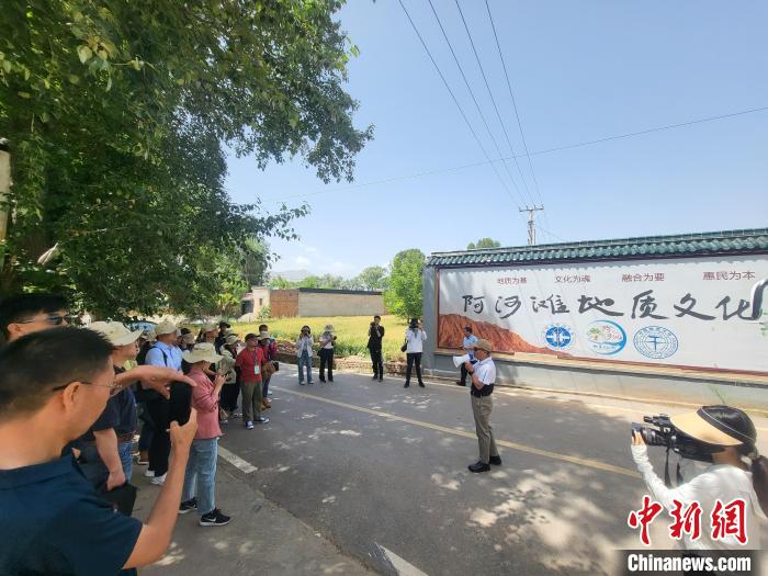 圖為中國(guó)地質(zhì)大學(xué)(北京)教授張緒教介紹村落情況。　胡友軍 攝