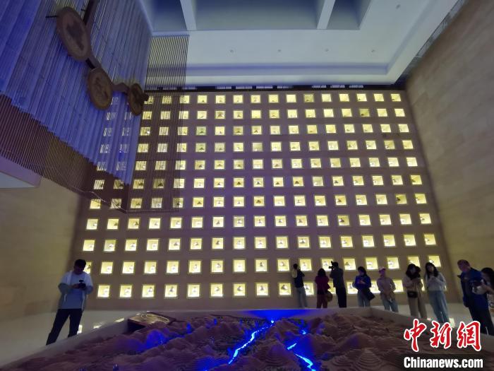 圖為河湟文化博物館序廳的左右彩陶墻放置的374件彩陶?！?zhí)砀?攝