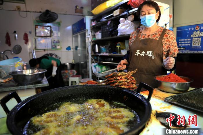 圖為平安驛·河湟民俗文化體驗(yàn)地內(nèi)的商戶炸干板魚(yú)?！⊙Φ?攝