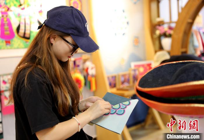 圖為民眾體驗國家級非遺項目盤繡技藝?！⊙Φ?攝