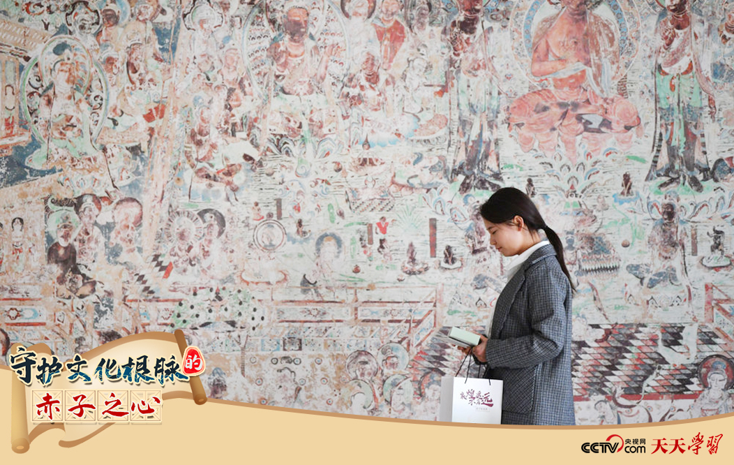 2023年4月25日，敦煌研究院文物數(shù)字化保護團隊創(chuàng)意營銷人員廖雪婷從一幅高保真復制壁畫前走過。