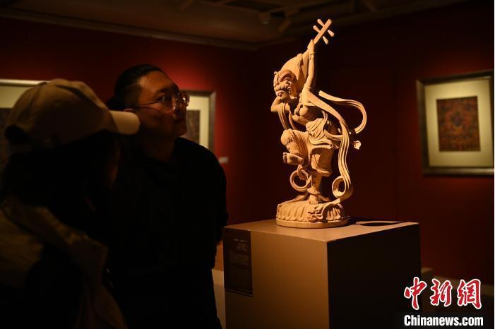 圖為季茂杰向參觀者介紹自己創(chuàng)作敦煌木雕的過程。李亞龍 攝</p>
<p>