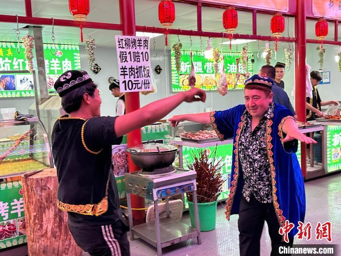 圖為餐飲經(jīng)營者在“西涼不夜城”跳起舞蹈引客?！〈魑牟?攝</p><p>