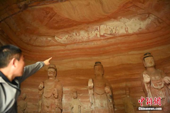 7月15日，甘肅省平?jīng)鍪袥艽h百里石窟長廊中的南石窟寺1號(hào)窟內(nèi)，工作人員介紹窟內(nèi)僅存的浮雕——佛傳故事。百里石窟長廊位于涇川縣境內(nèi)，由512個(gè)石窟、5眼窟中石井組成，現(xiàn)存王母宮石窟、鳳凰山石窟、南石窟寺、丈八寺石窟、羅漢洞石窟、太山寺石窟等規(guī)模較大的石窟群，還有數(shù)量眾多的小石窟群。南石窟寺開鑿于北魏永平三年，其中1號(hào)窟屬于大型七佛窟，七佛高達(dá)6米。中新社記者 李亞龍 攝</p>
<p>