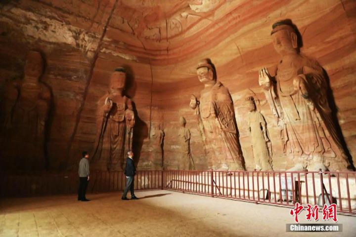 7月15日，游人參觀甘肅省平?jīng)鍪袥艽h百里石窟長廊中的南石窟寺1號(hào)窟。百里石窟長廊位于涇川縣境內(nèi)，由512個(gè)石窟、5眼窟中石井組成，現(xiàn)存王母宮石窟、鳳凰山石窟、南石窟寺、丈八寺石窟、羅漢洞石窟、太山寺石窟等規(guī)模較大的石窟群，還有數(shù)量眾多的小石窟群。南石窟寺開鑿于北魏永平三年，其中1號(hào)窟屬于大型七佛窟，七佛高達(dá)6米。中新社記者 李亞龍 攝