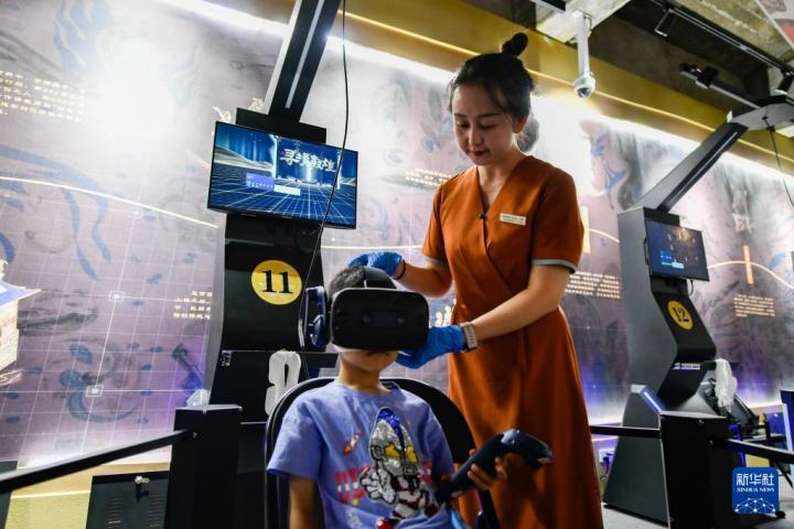 7月22日，敦煌研究院文化弘揚部工作人員引導游客佩戴使用VR設(shè)備。新華社記者 郎兵兵 攝</p>
<p>